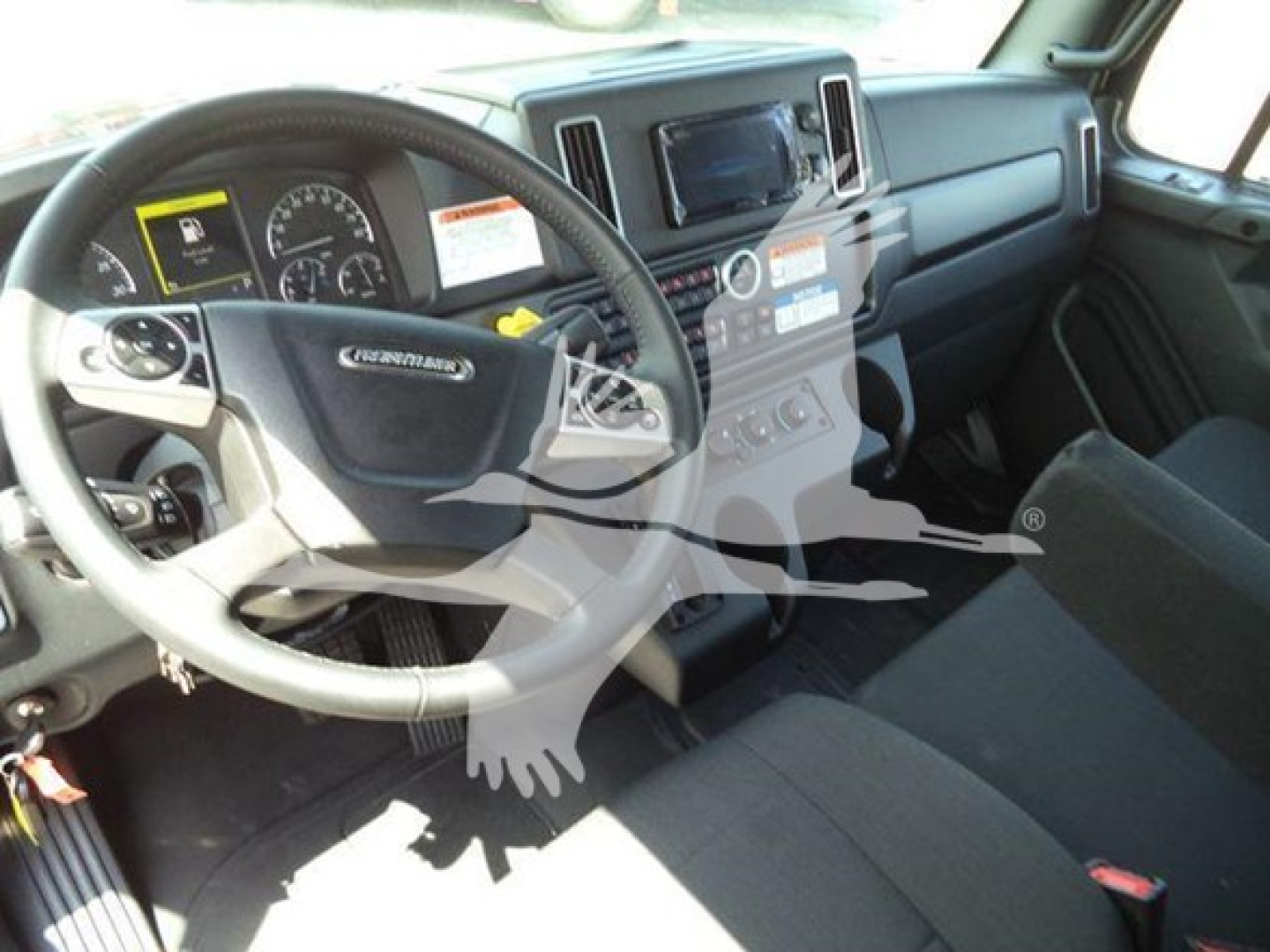 Freightliner M2 106 Plus interior showing steering wheel dashboard and center console.