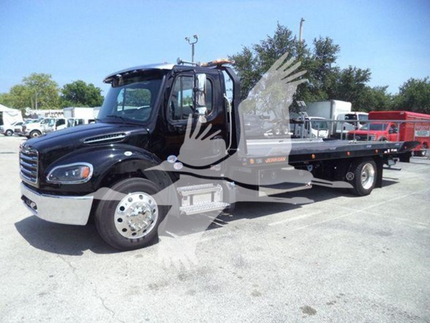 Flatbed tow truck 2027 Freightliner M2 106 Plus in black, side view showing rollback bed and chrome wheels, cab interior visible through open door.