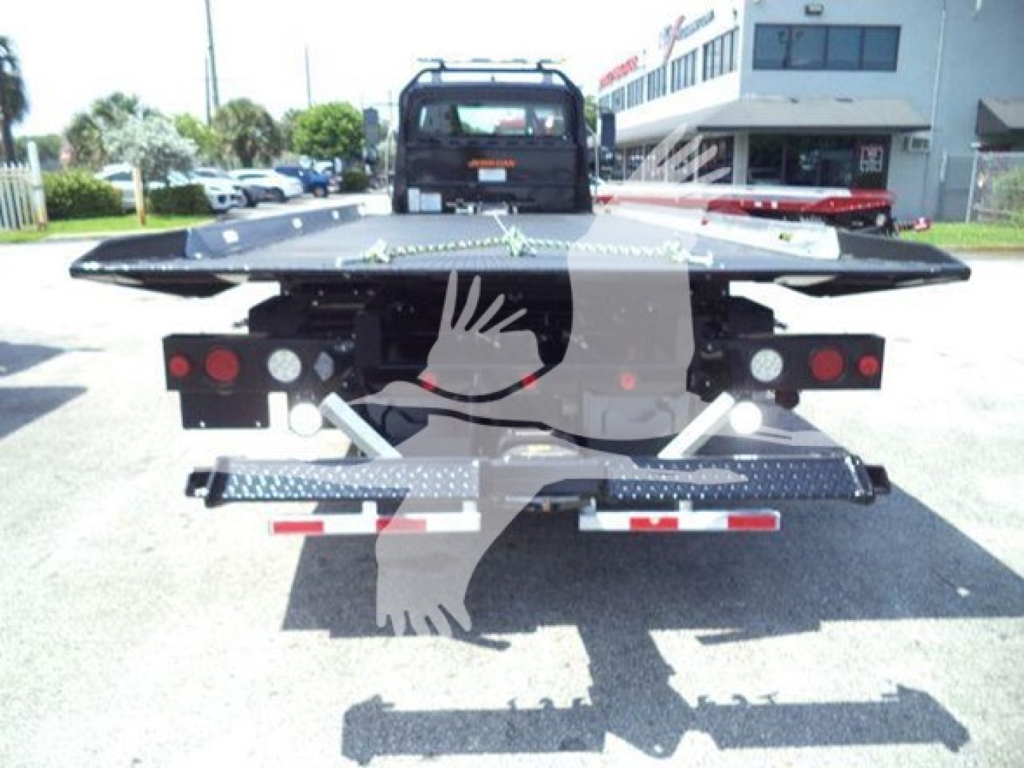 Freightliner M2 106 Plus rollback truck rear view showing hydraulic platform and taillights.