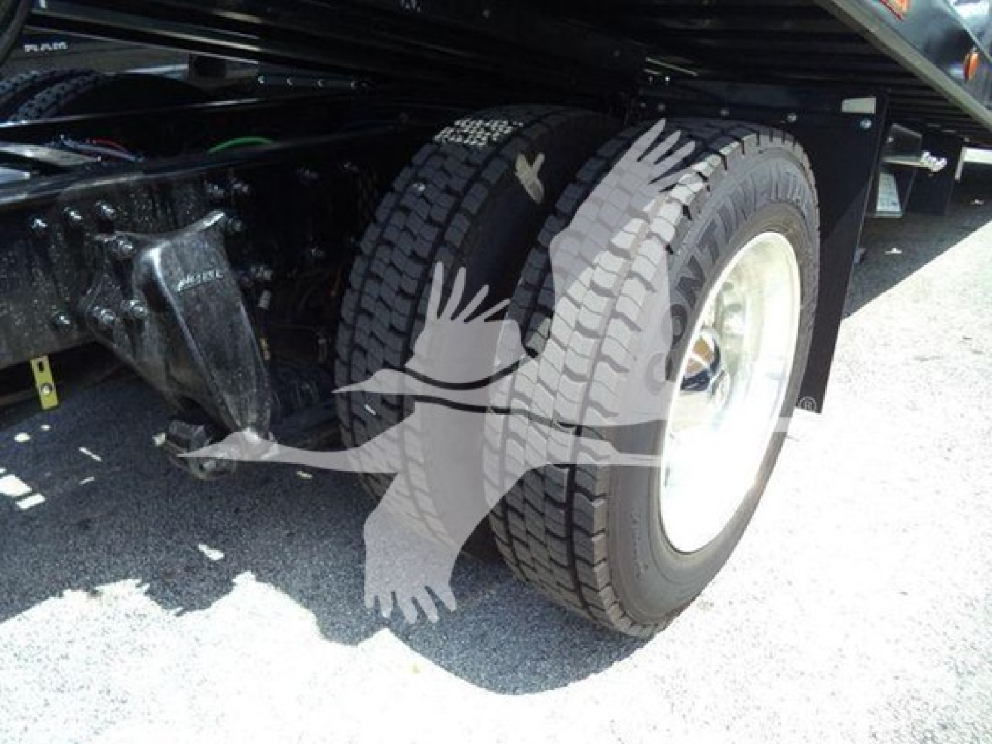 Freightliner M2 106 Plus rollback truck wheel and front suspension showing tire and wheel well.