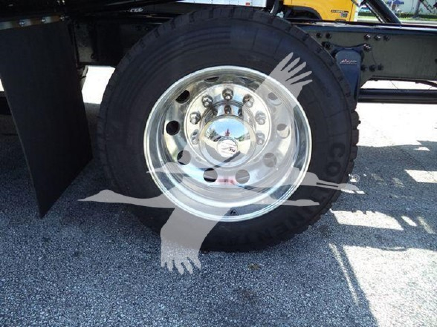  Freightliner M2 106 Plus rollback truck wheel and hubcap detail showing chrome wheel with lug nuts and tire. 