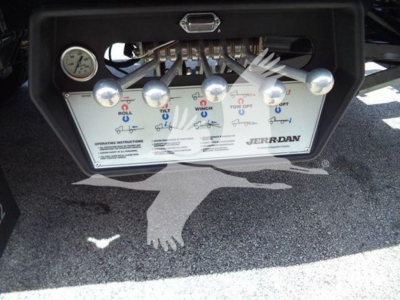 Truck control panel with multiple levers and gauges for a rollback tow truck; visible labels include OFF/ON, and brand 'Jerrdan' near operating instructions.