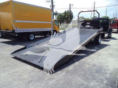 Freightliner M2 106 Plus rollback truck with an extended flatbed ramp in view. Side and rear show loading platform and wheel setup.