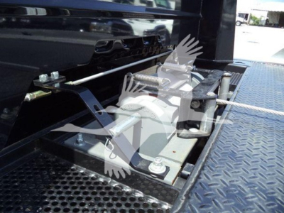 Truck rollback platform attachment with metal bolts and hydraulic lines, platform steps, and diamond plate surface.