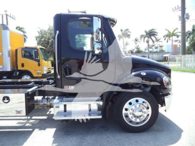 Freightliner M2 106 Plus rollback truck side view showing cab and chrome step with fuel tank and wheel. Text on side includes model badge and chrome exhaust area.