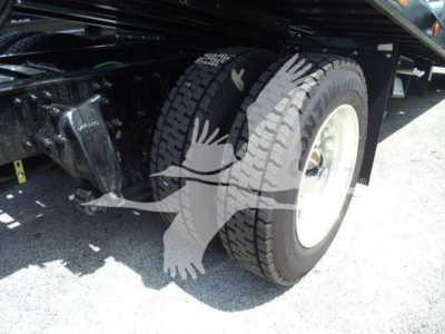 Freightliner M2 106 Plus rollback truck wheel and front suspension showing tire and wheel well.