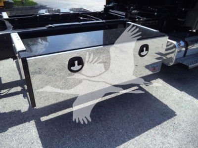 Freightliner M2 106 Plus toolbox/storage box mounted on rollback truck chassis with dual circular access panels; glossy metallic surface.