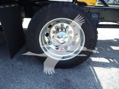  Freightliner M2 106 Plus rollback truck wheel and hubcap detail showing chrome wheel with lug nuts and tire. 