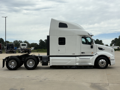 Peterbilt 579 conventional sleeper tractor viewed from side, white cab, dual rear axles, fifth wheel chassis, no trailer attached, VIN 1XPBD49X5LD616700 visible in listing context.