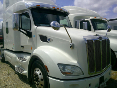 Peterbilt 579 truck cab in white, front grille, side mirror, and sleeper cab visible.