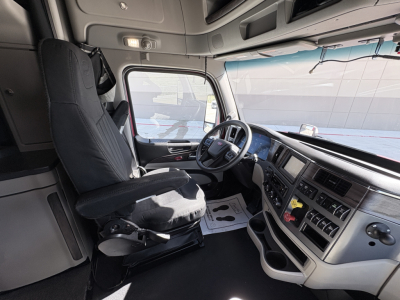 Peterbilt 579 truck interior driver seat and dashboard view with steering wheel, control panel, and center console.