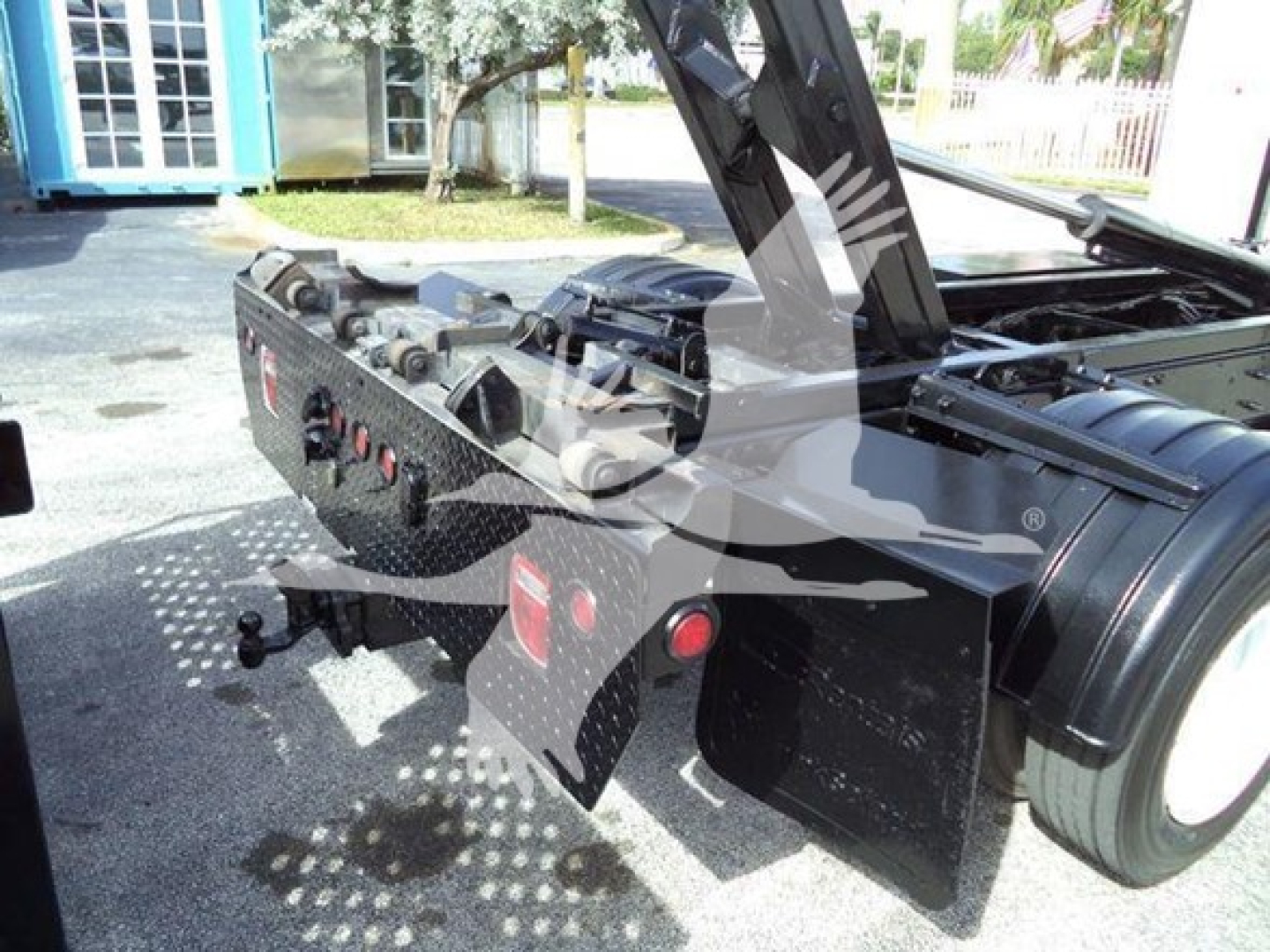 Rear view of a 2017 Hino 258LP hooklift truck showing chrome and black metal body, hydraulic components, tow hitch, and rear fender area.