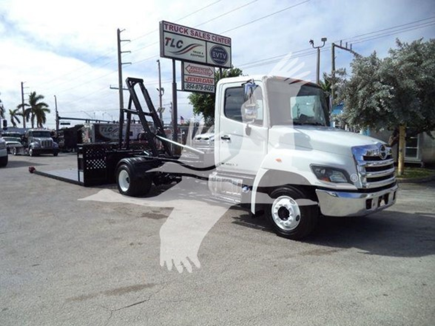 2017 Hino 258LP hooklift truck in service with loading arms and chassis visible.
