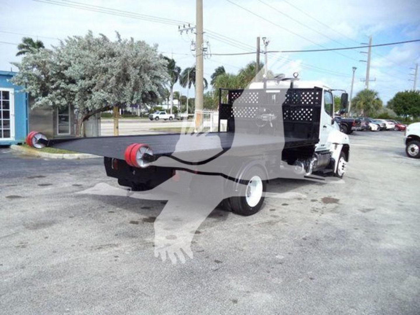 2017 Hino 258LP hooklift truck rear view showing flatbed with hooklift boom and cab