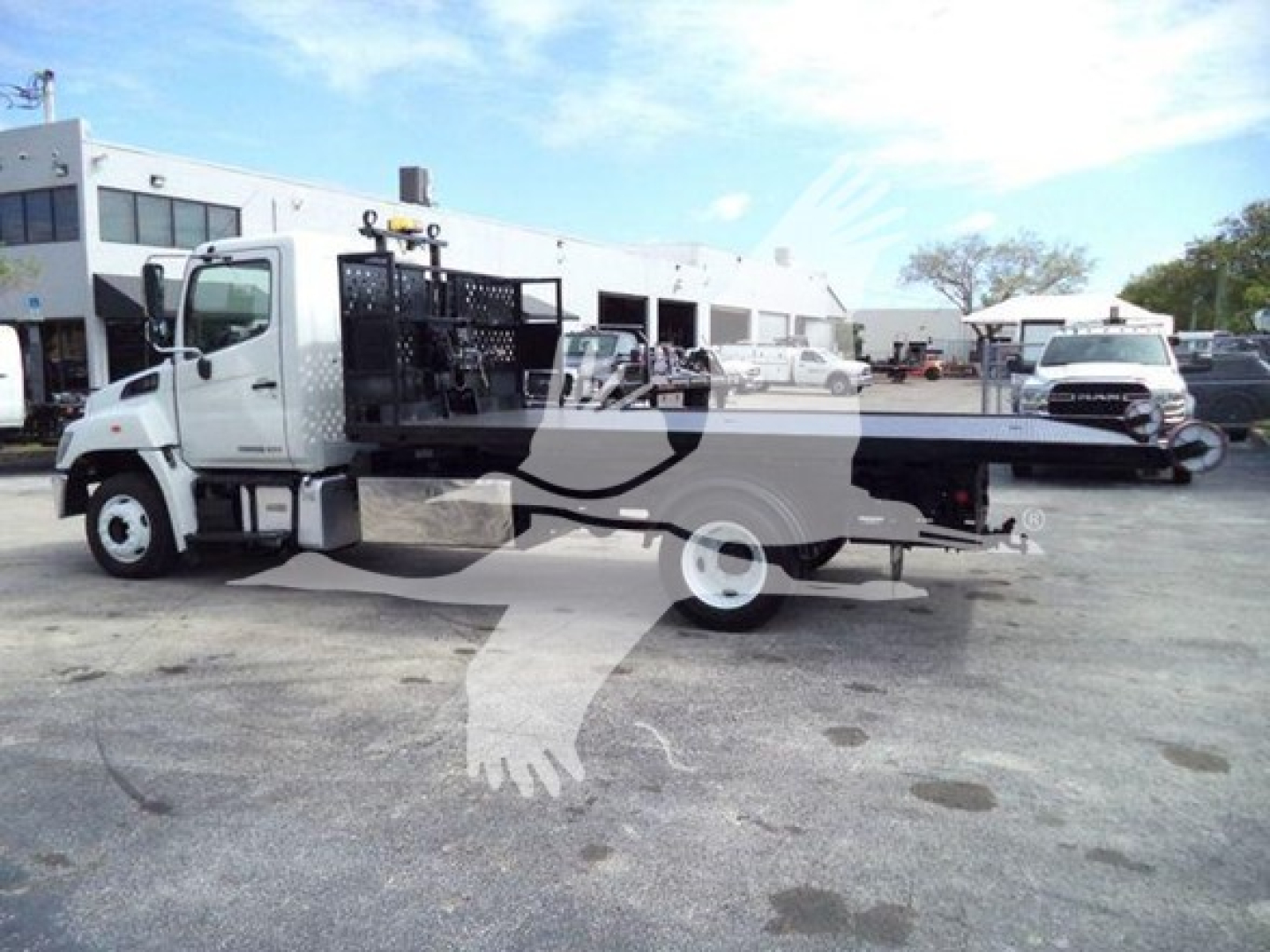 2017 Hino 258LP hooklift truck in side view showing flatbed with hydraulic hoist and toolbox, white cab, stock number T52712