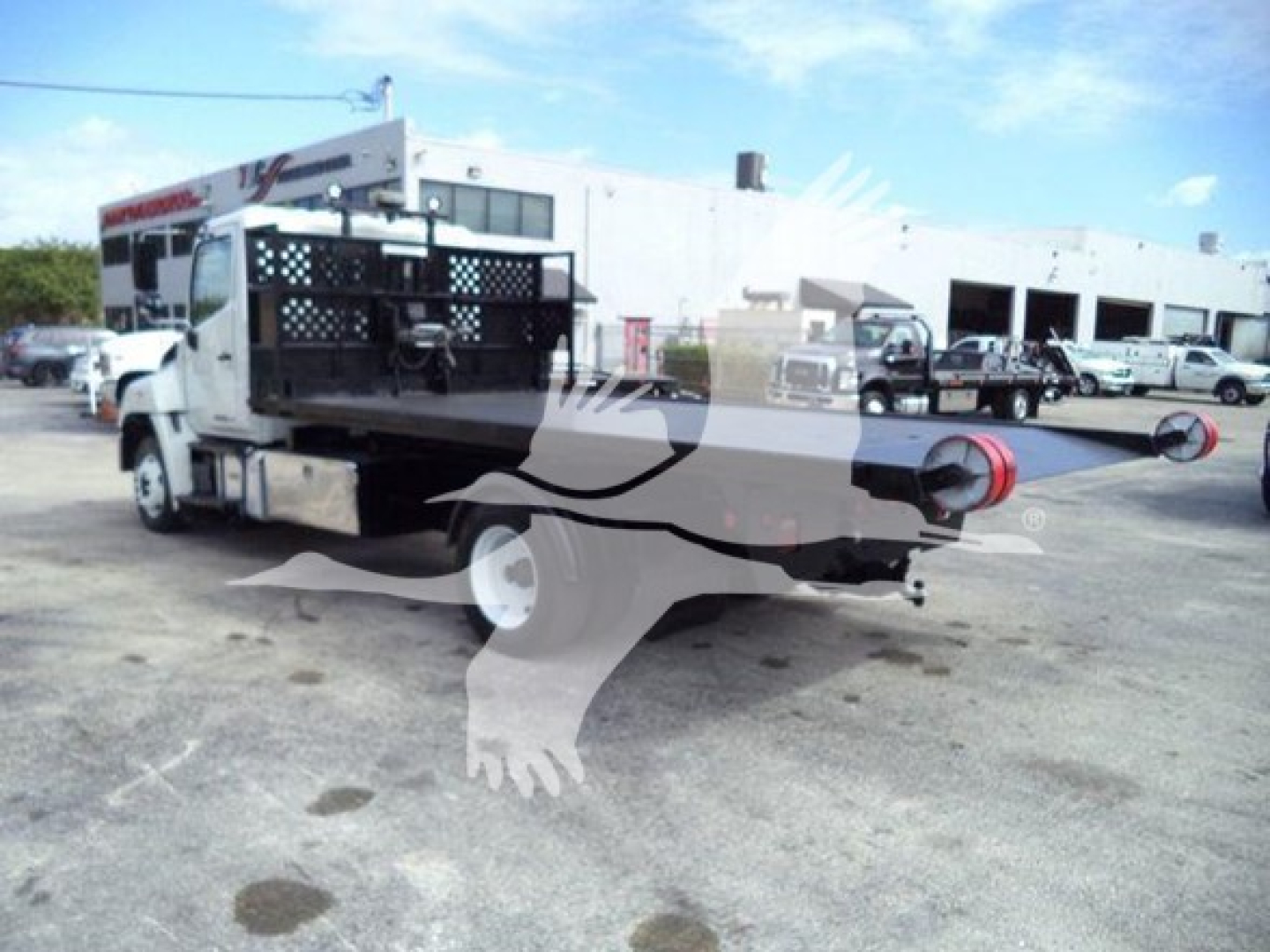 Truck bed of a 2017 Hino 258LP hooklift vehicle showing rear apparatus and port fittings.