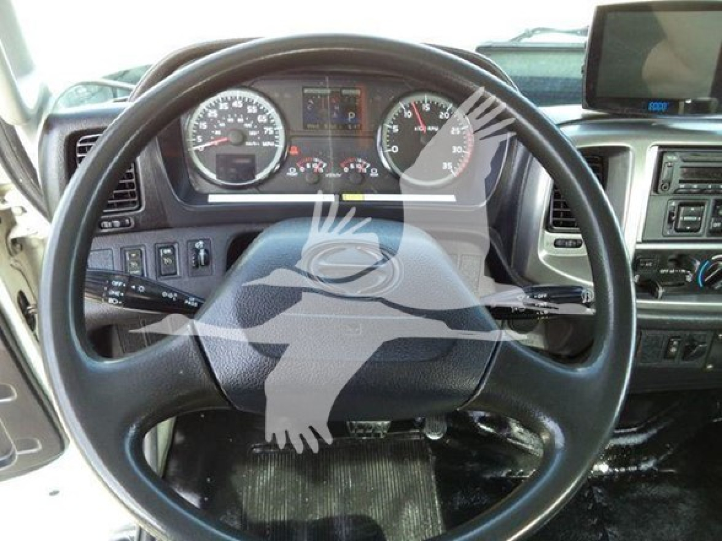 Truck interior steering wheel and dashboard view from a 2017 Hino 258LP listing.