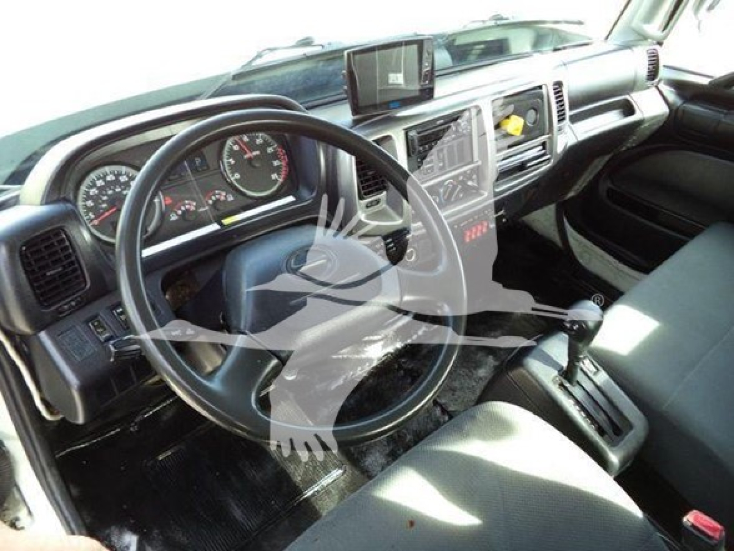 Cab interior of a used 2017 Hino 258LP viewing the steering wheel, dashboard, and center console.