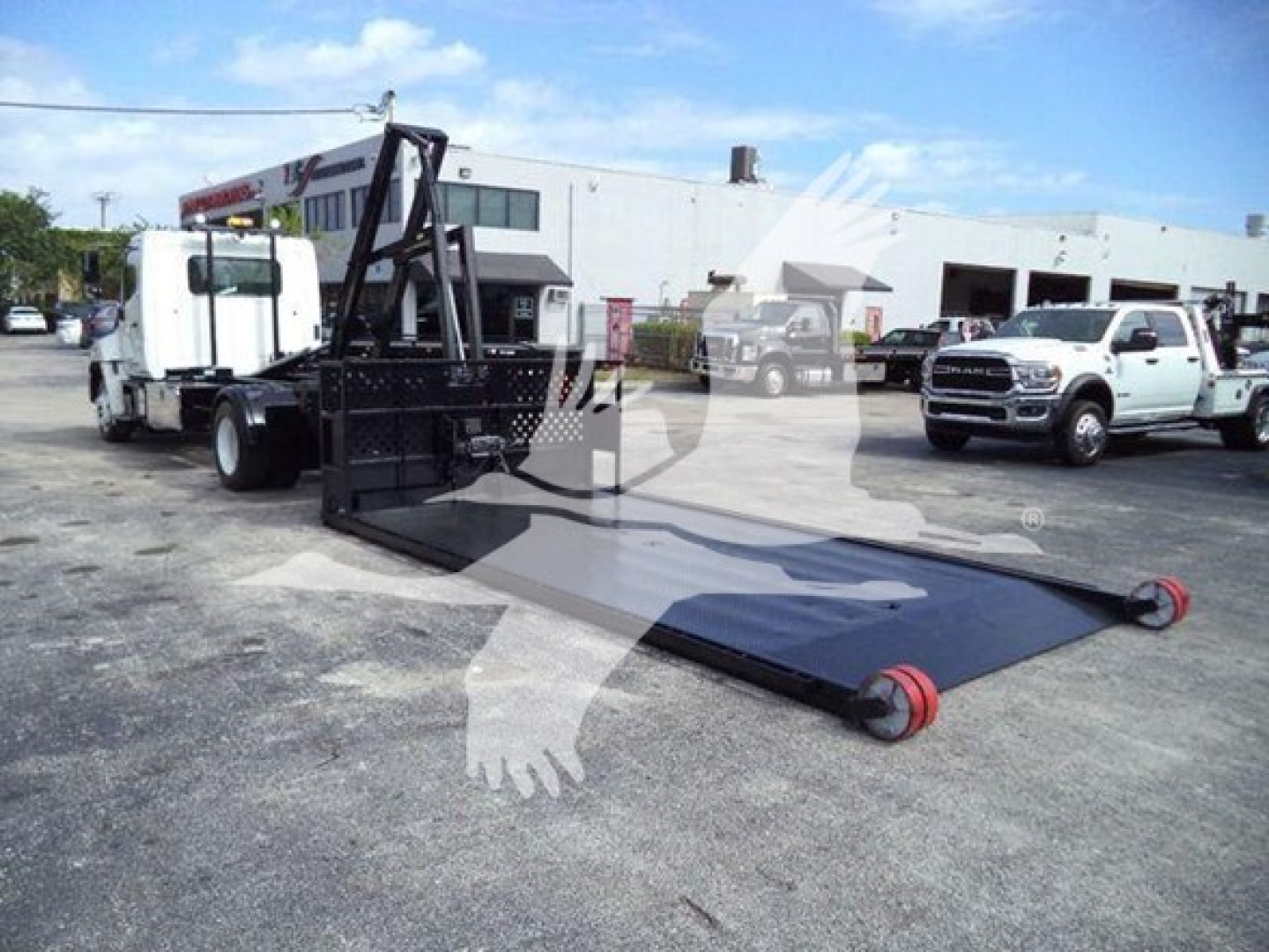 Hino 258LP hooklift truck with long flatbed and hydraulic lifting arm in a dealership lot.
