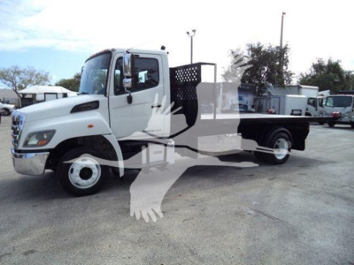 Truck in lot showing cab, hooklift bed with metalwork. Visible text on image includes none clearly legible; no readable labels or stickers discernible.