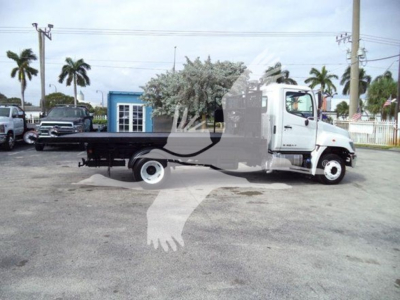 2017 Hino 258LP hooklift truck in a parking lot showing side view with flatbed and white cab.