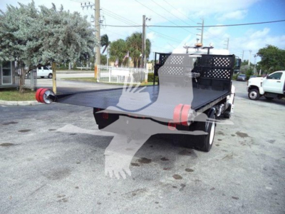 Rear view of a used 2017 Hino 258LP hooklift truck with flatbed extended, black metal stake sides, red tie-downs, and license plate area obscured.