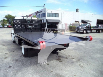 Hino 258LP hooklift truck bed with flatbed and rear tail lights, viewed from rear-right in a dealership lot.