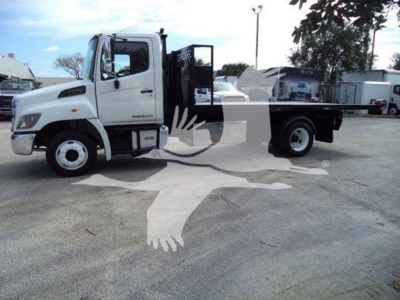 White Hino 258LP hooklift truck side view with black hooklift bed. Visible text includes HINO on door and CHASSIS/engine area details, with no legible additional labels.