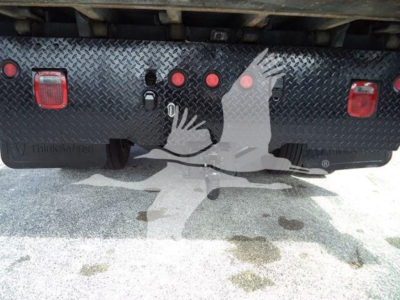 Rear view of a hooklift truck showing taillights, reflectors, and a diamond-plate bumper with three circular warning lights and two rectangular red lights.
