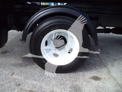 Front wheel and fender of a Hino 258LP hooklift truck showing wheel and tire assembly and rear frame.