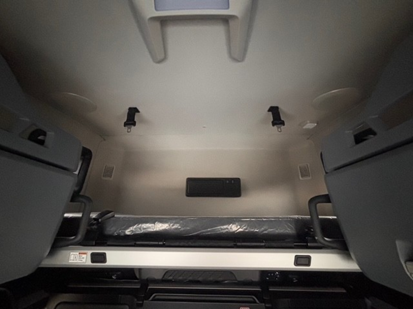 Truck cab interior showing bunk area and storage compartments in a Mack PR64T76H sleeper cab.