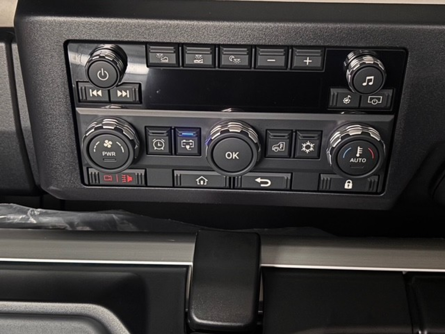 Dashboard controls of a 2026 Mack PR64T76H showing radio and climate control knobs and buttons.