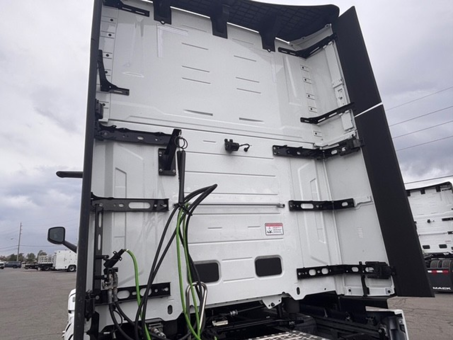Mack PR64T76H truck cab interior showing rear wall and side access panels with wiring harnesses.