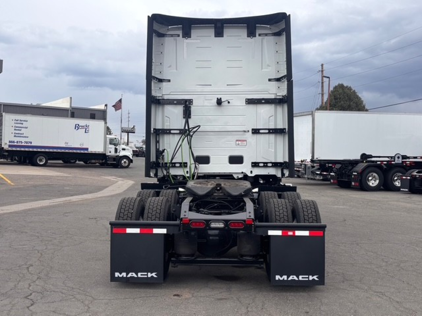 Mack PR64T76H truck rear view showing chassis and mud flaps with Mack branding.