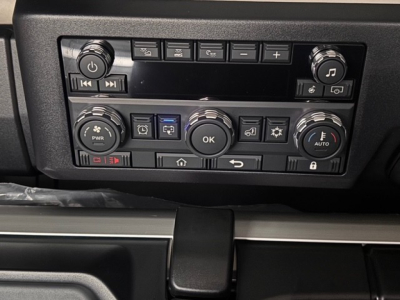 Dashboard controls of a 2026 Mack PR64T76H showing radio and climate control knobs and buttons.
