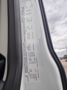 Truck window sticker on a Mack PR64T76H showing manufacturer and GVWR/ axle ratings and various specifications.