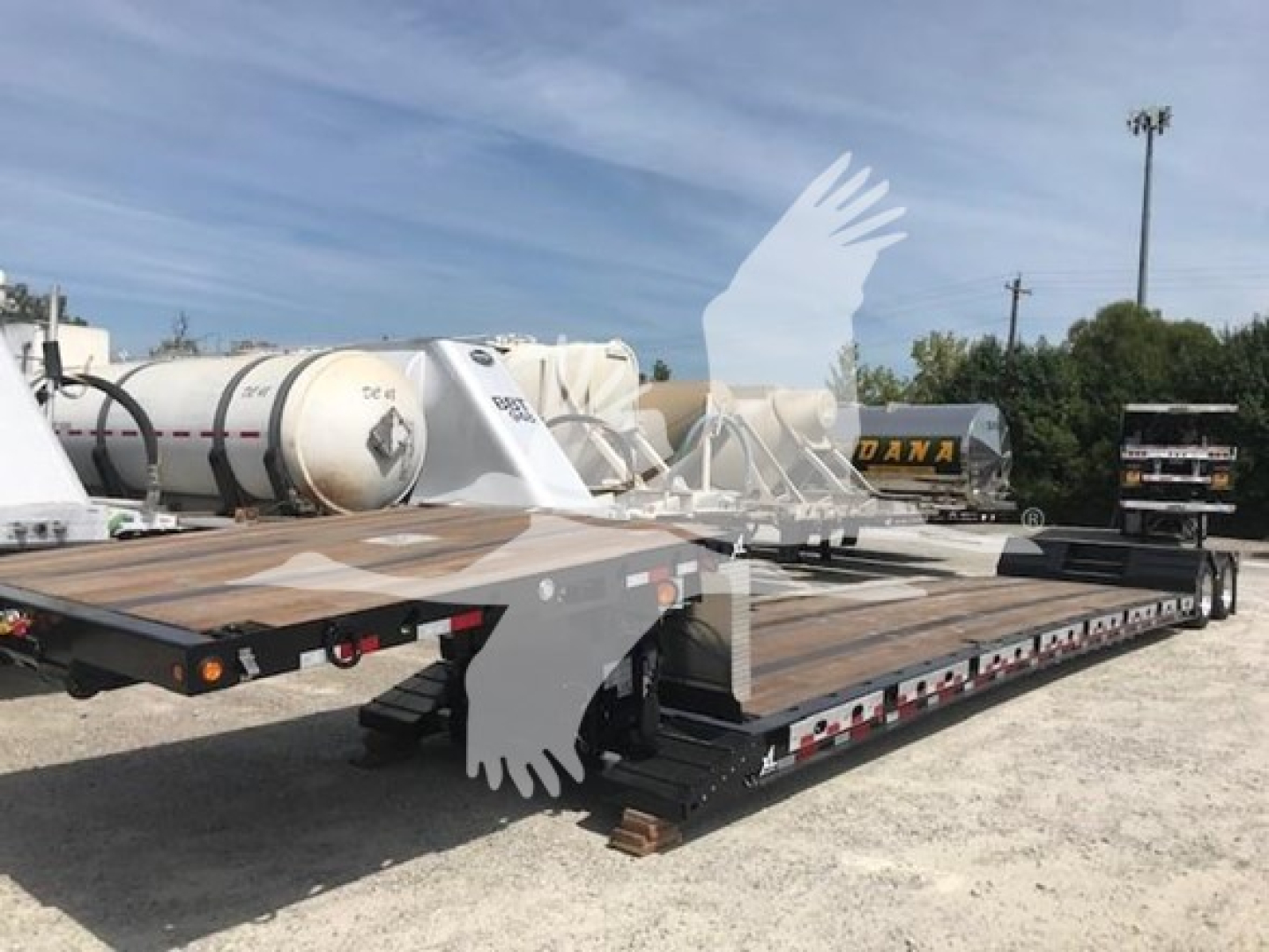 XL Specialized XL80MFGA lowboy trailer showing wooden deck and dual axles with ramps