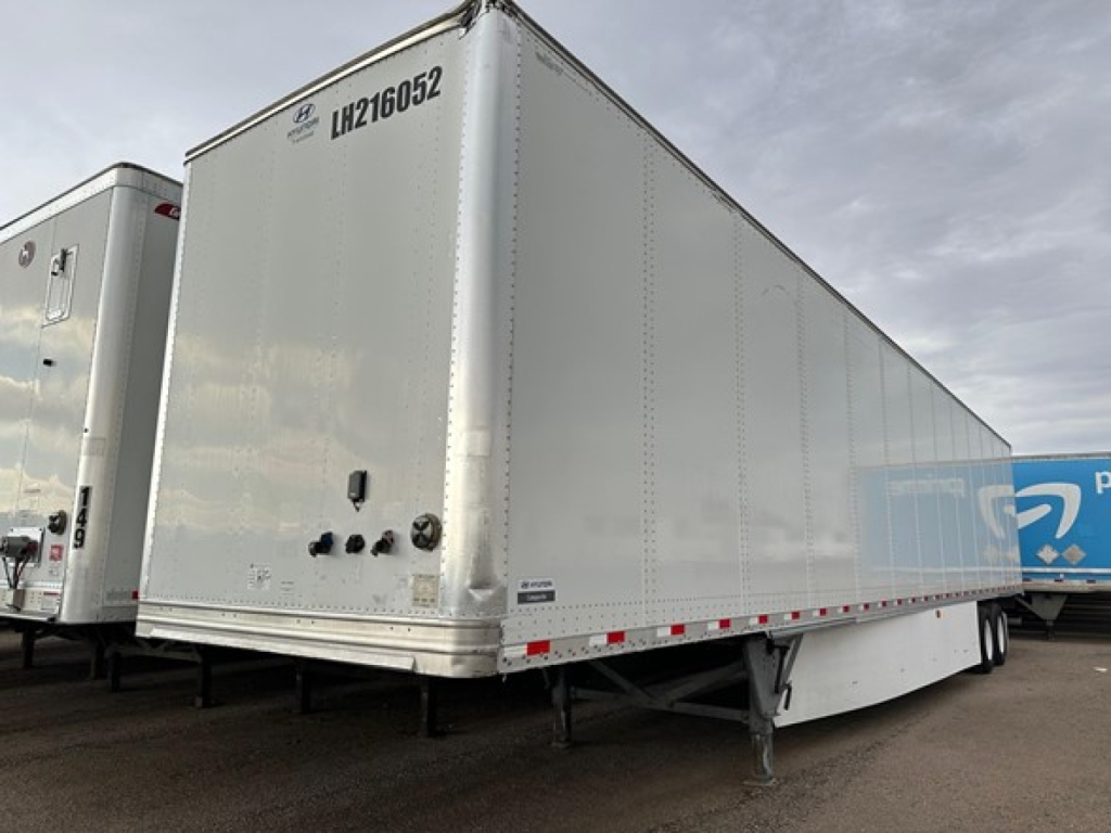 Trailer side view showing 2017 Hyundai air ride dry van with roll door and tag numbers on front corner.