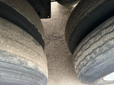 Trailer axle dual tires with light road grime on tread; wheel hubs visible; part of rear dual tires under a Hyundai air ride dry van trailer.