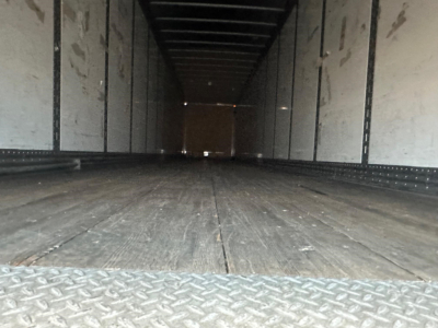 Trailer interior showing empty dry van cargo area with wooden floor and steel side walls