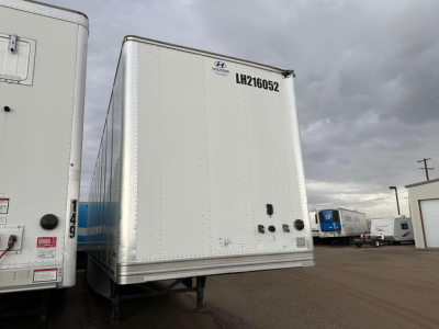 Trailer rear showing LH210652 and various plumbing/valves on the back of a Hyundai air ride dry van with roll door in a yard.