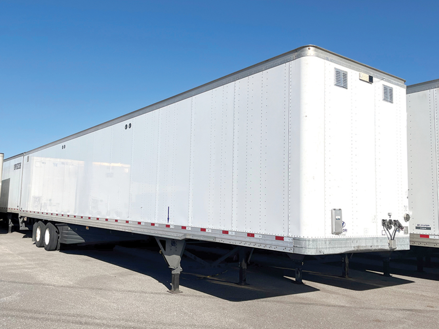 Trailer semi-trailer aluminum box showing side and front with landing gear and hitch.