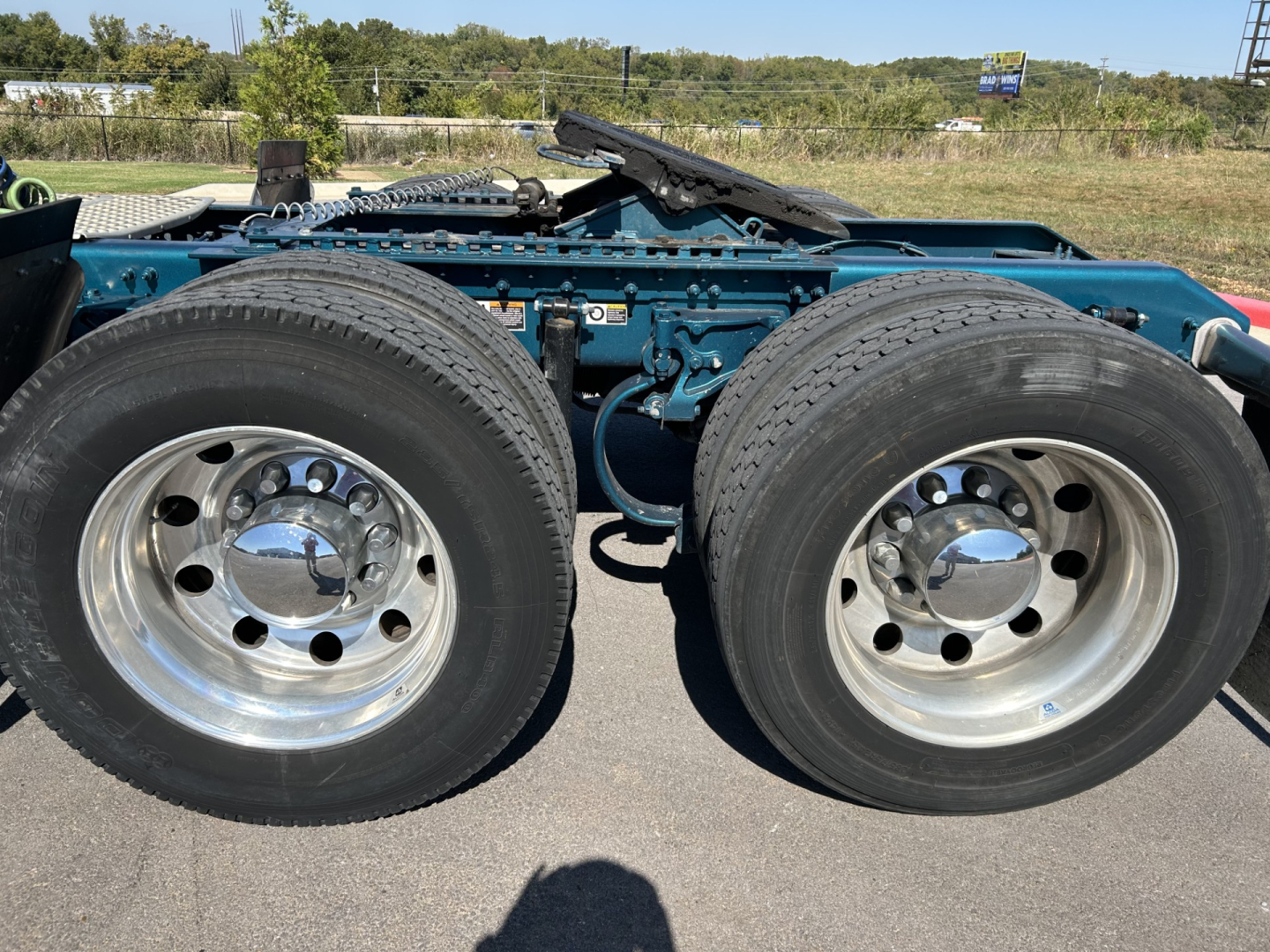 Kenworth W900L truck rear dual rear wheels and blue chassis frame showing tires and rims.