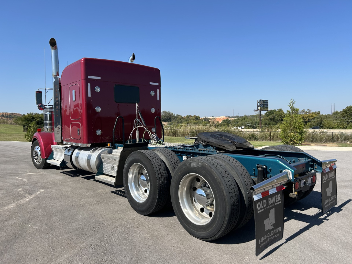 Kenworth W900L truck chassis and sleeper cab side view showing dual rear axles and fuel tanks.