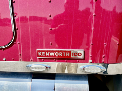 Kenworth W900L truck rear badge Kenworth 100 emblem and chrome trim on magenta truck