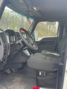 Tow truck cab interior showing driver seat, steering wheel, and dashboard in a new Kenworth T280 with VIN 2NK3HM6X0SM135470 and stock U1038