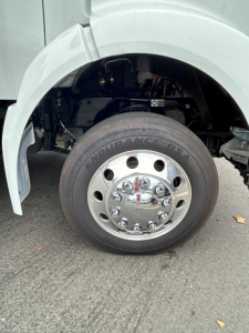 Kenworth T280 front wheel showing Enfurance tire and chrome hub cap, fender, and suspension components visible