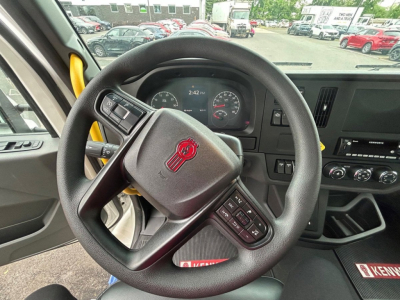 Steering wheel and dashboard of a new Kenworth T280 truck showing instrument cluster and center console.