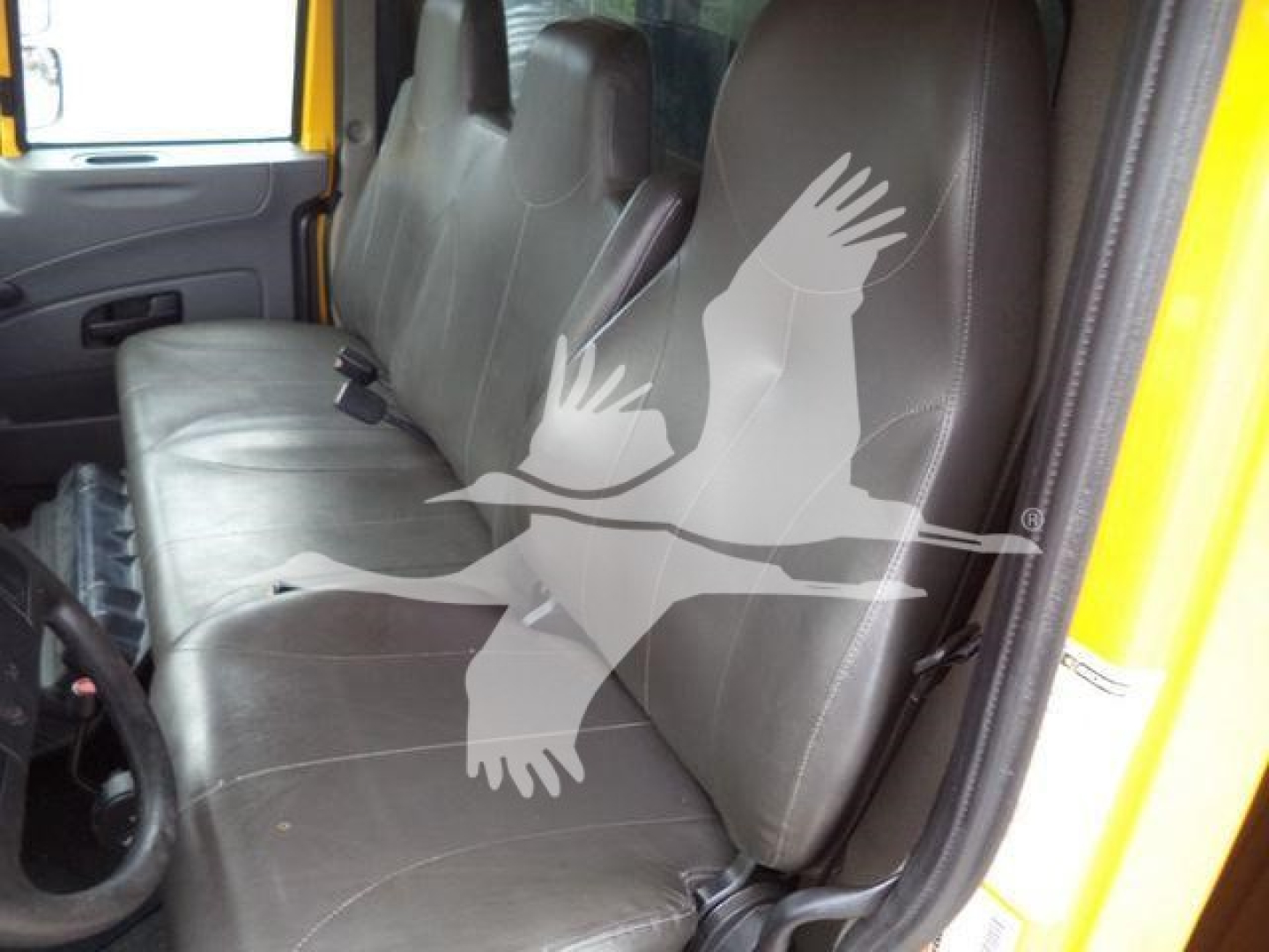 Interior of a 2019 International 4300 dump truck cab showing two front seats and grey upholstery with a watermark graphic overlaid.