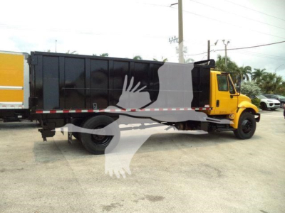 Truck with black dump bed and yellow cab, side view of a 2019 International 4300 dump truck.